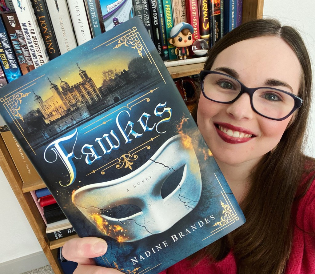 Madelynn Orion Holding Fawkes by Nadine Brandes in front of a bookshelf