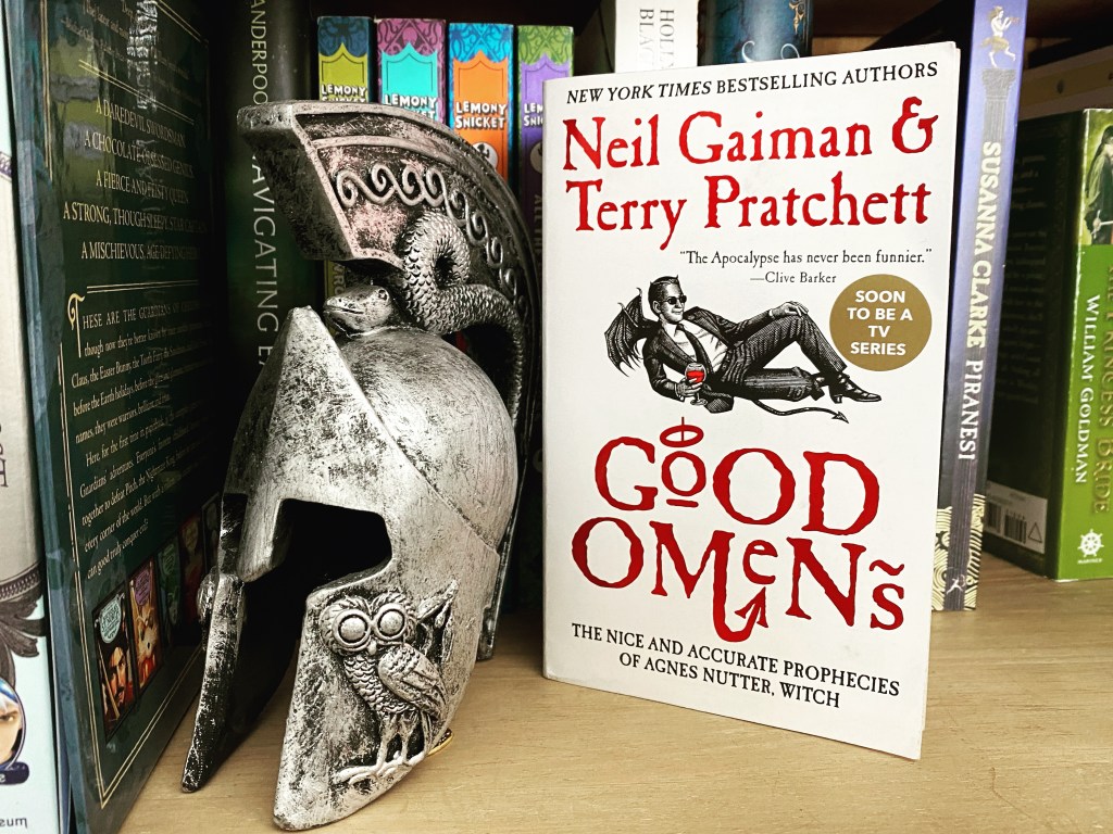 Good Omens Next to an old helmet on a book shelf