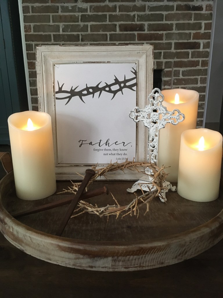 Image of a Good Friday display: candles, cross, crown of thorns, nails, and Scripture art print