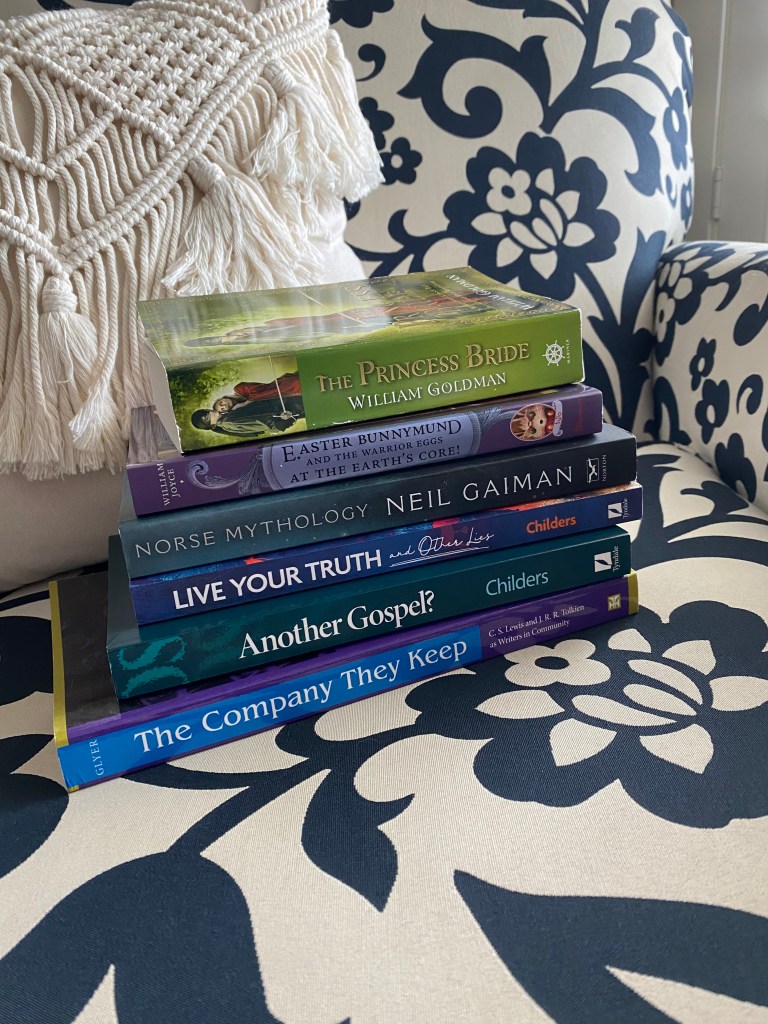 Stack of books on a navy and white floral chair