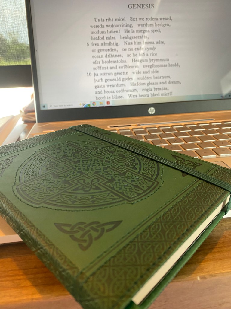 Ornate green celtic notebook in front of old english poetry