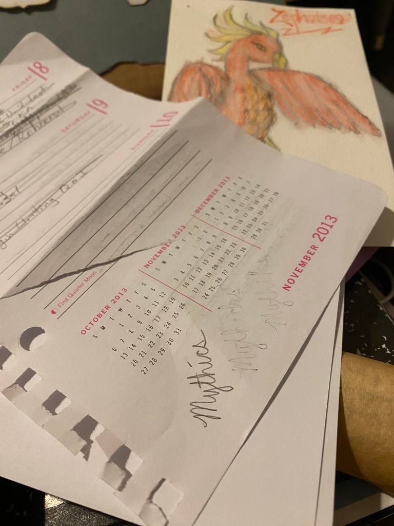 Calendar page from 2013 with "Mythics" written on it, with phoenix art in background