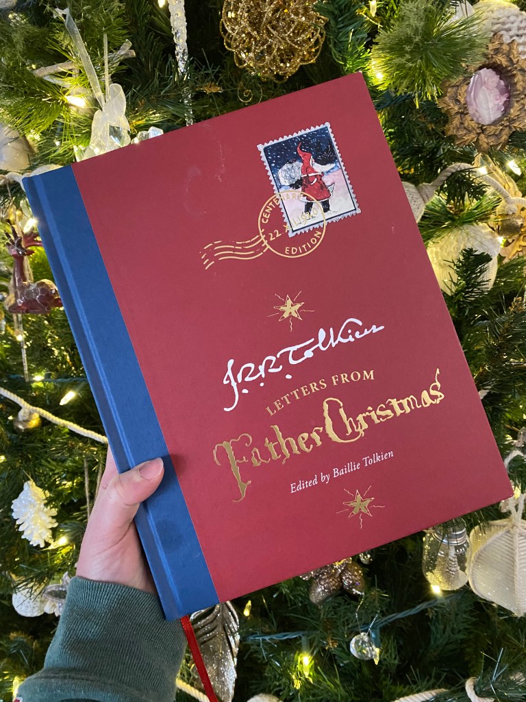 The book Letters from Father Christmas by J. R. R. Tolkien, in front of a Christmas tree