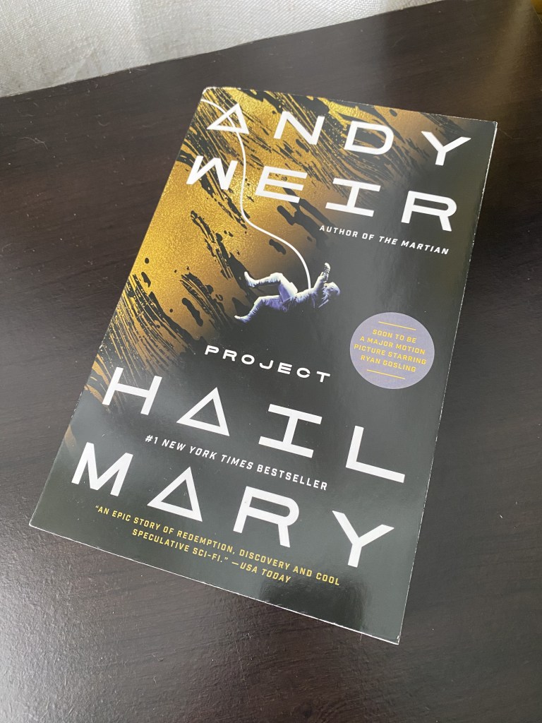 Project Hail Mary by Andy Weir on a black shelf