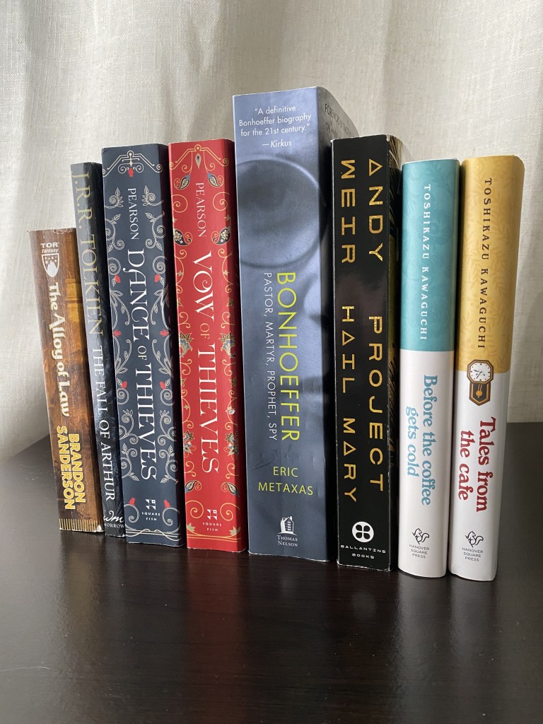 8 books standing on a black shelf