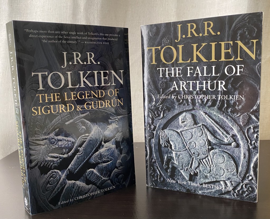 Two J. R. R. Tolkien books standing on a black shelf